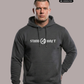 Mann in dunkelgrauem Hoodie mit weißem Aufdruck „STAND HAFT“ und Adler-Logo blickt ernst vor grauem Hintergrund. AI-generated.
