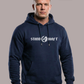 Mann in blauem Hoodie mit weißem Aufdruck „STAND HAFT“ und Adler-Logo blickt ernst vor grauem Hintergrund. AI-generated.