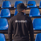 Ein Mann von hinten in einer schwarzen Trainingsjacke mit weißem „Standhaft“-Schriftzug im altdeutschen Stil auf dem Rücken.