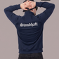 Ein Mann von hinten in einer dunkelblauen Trainingsjacke mit weißem „Standhaft“-Schriftzug im altdeutschen Stil auf dem Rücken.
