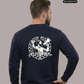 Rückansicht eines Mannes im dunkelblauen Sweatshirt mit großem „Matchday“-Rückenprint, Hand an der Hüfte, grüne Hose.
