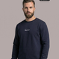 Bärtiger Mann im dunkelblauen Sweatshirt mit weißem Brustaufdruck „Standhaft“, frontaler Blick, dazu dunkle Hose.