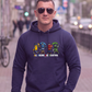 Mann mit Sonnenbrille trägt dunkelblauen Hoodie mit „All Colors Are Beautiful“-Grafikprint in urbaner Umgebung.