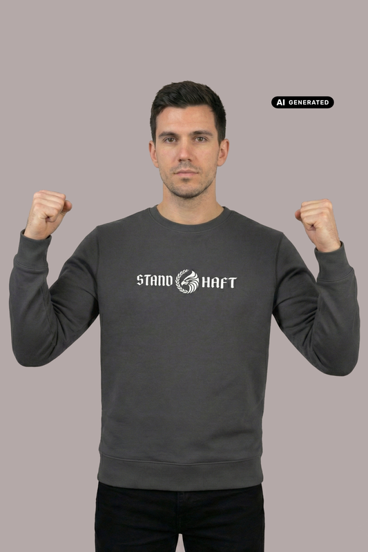 Mann in dunkelgrauem Pullover mit weißem Aufdruck „STAND HAFT“ und Adler-Logo zeigt geballte Fäuste vor grauem Hintergrund. AI-generated