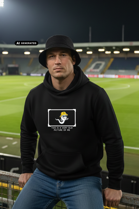 Ein Mann mit schwarzem Anglerhut trägt einen schwarzen Hoodie mit einer Comic-Grafik auf der Brust.