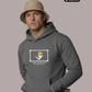 Ein Mann mit beigem Anglerhut trägt einen dunkelgrauen Hoodie mit einer Comic-Grafik auf der Brust.