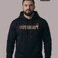Ein Mann mit Bart trägt einen schwarzen Kapuzenpullover mit bunt gefülltem „STANDHAFT“-Schriftzug auf der Brust.