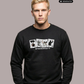 Blonder Mann in schwarzem Pullover mit der Aufschrift „STANDHAFT“ und vier Motivkarten, dazu blaue Jeans.