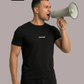 Schreiender Mann im schwarzen T-Shirt mit weißem Aufdruck „Standhaft“, der ein Megafon an den Mund hält.