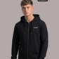 Mann im schwarzen Hoodie mit Reißverschluss und weißem Brustaufdruck „Standhaft“, frontaler Blick.