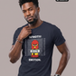 Ein Mann trägt ein dunkelblaues T-Shirt mit dem Comic-Print einer Pyro-Figur vor einer Größenskala und den Schriftzügen „TATMOTIV:“ und „EMOTION.“.