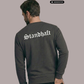 Ein Mann von hinten in einem dunkelgrauen Pullover mit weißem „Standhaft“-Schriftzug im altdeutschen Stil auf dem Rücken.
