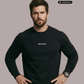 Ein Mann trägt einen schwarzen Pullover mit einem kleinen, weißen „Standhaft“-Schriftzug auf der Brust.