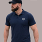 Bärtiger Mann im Profil mit Cap und dunkelblauem Poloshirt mit Lorbeerkranz-Logo, Blick nach links gerichtet.