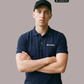 Ein Mann trägt ein dunkelblaues Poloshirt mit einem kleinen, weißen „Standhaft“-Schriftzug auf der linken Brust.