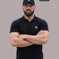 Bärtiger Mann mit Cap im schwarzen Poloshirt mit Lorbeerkranz-Logo, mit verschränkten Armen frontal fotografiert.