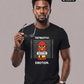 Ein Mann mit einer Sonnenbrille in der Hand trägt ein schwarzes T-Shirt mit dem Comic-Print einer Pyro-Figur vor einer Größenskala und den Schriftzügen „TATMOTIV:“ und „EMOTION“.