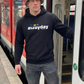 Ein Mann mit Fischerhut steht an einer Zugtür; er trägt einen schwarzen „awayday“-Hoodie und graue Jeans.