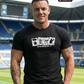 Muskulöser Mann im schwarzen T-Shirt mit dem Aufdruck „STANDHAFT“ und vier Motivkarten in einem Stadion.