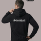 Ein Mann von hinten in einem schwarzen Hoodie mit weißem „Standhaft“-Schriftzug im altdeutschen Stil auf dem Rücken.
