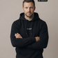 Ein Mann trägt einen schwarzen Hoodie mit einem kleinen, weißen „Standhaft“-Schriftzug auf der Brust.