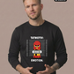 Ein Mann trägt einen schwarzen Pullover mit dem Comic-Print einer Pyro-Figur vor einer Größenskala und Schriftzügen.