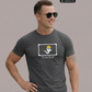 Ein Mann mit Sonnenbrille trägt ein dunkelgraues T-Shirt mit einer Comic-Grafik auf der Brust.