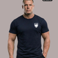 Ein Mann in frontaler Pose trägt ein dunkelblaues T-Shirt mit einem weißen Wappen-Logo samt Adlergrafik und „STANDHAFT“-Schriftzug auf der linken Brust.
