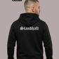 Ein Mann von hinten in einem schwarzen Hoodie mit weißem „Standhaft“-Schriftzug im altdeutschen Stil auf dem Rücken.